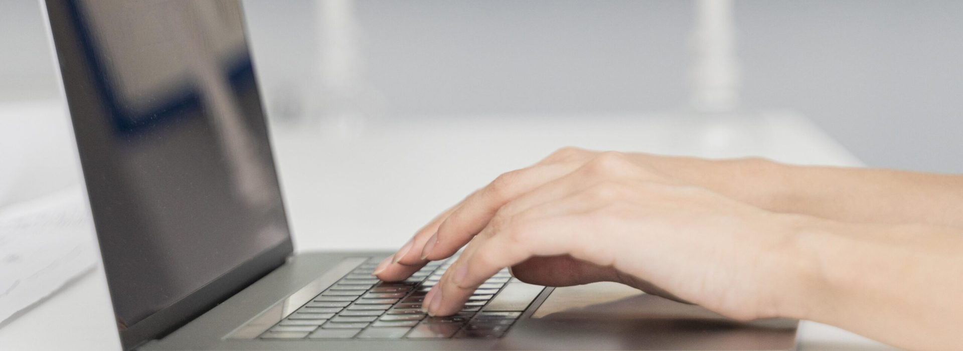 mujer-joven-escribiendo-en-un-teclado-de-computadora-portatil